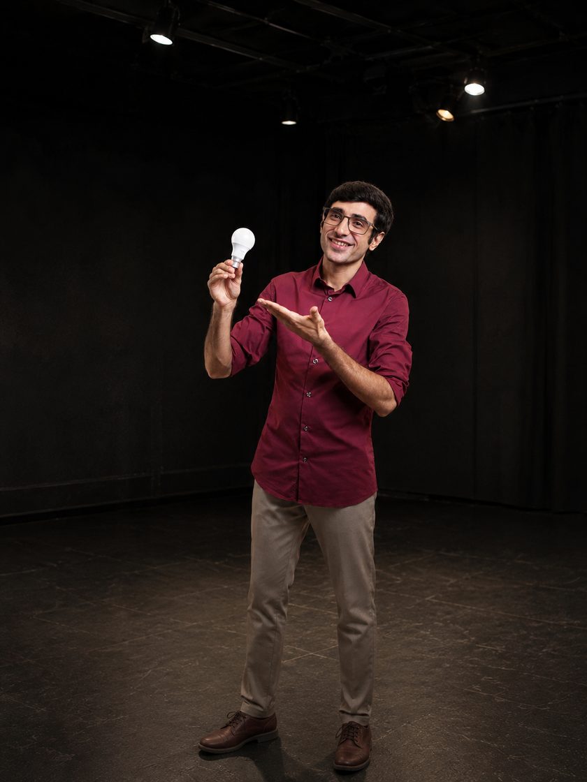 Smayan holding a lightbulb on a studio stage